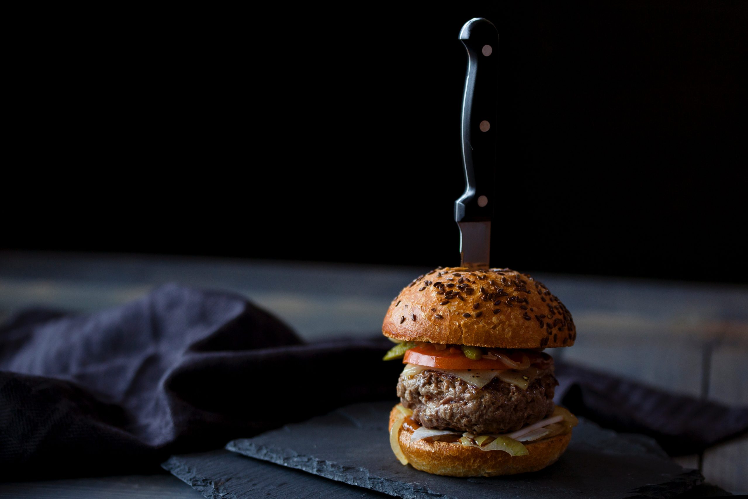 wallpaper Burger skewered with knife near black textile