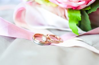 Silver-and-gold-colored rings near pink flower