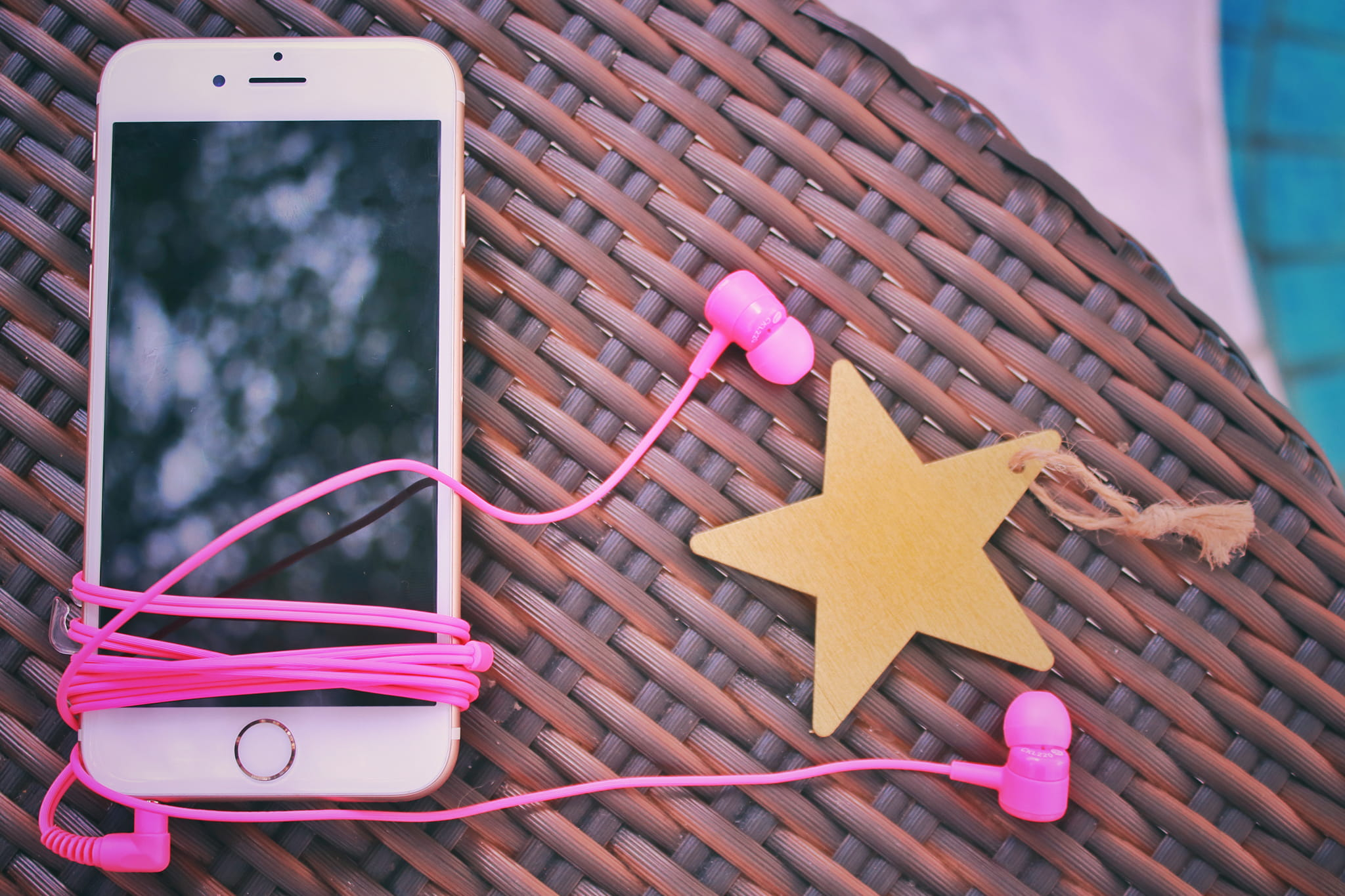 Wallpaper rose gold iPhone 6 with pink earphones on brown wicker table