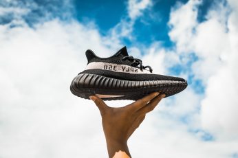 Black and white adidas Yeezy Boost 350 V2 shoe under blue sky wallpaper