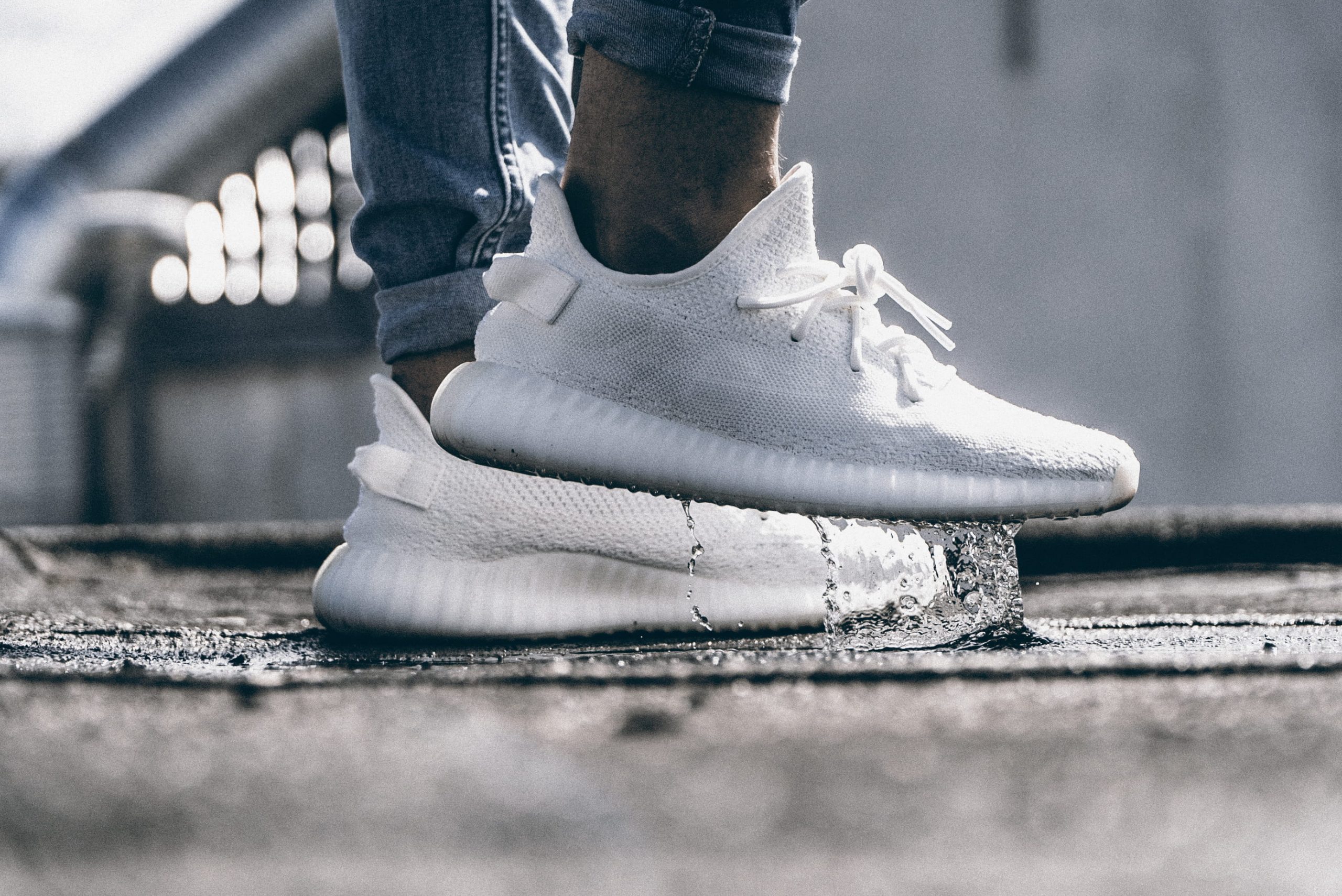 Person wearing pair of cream white Adidas Yeezy Boost 350 shoes wallpaper