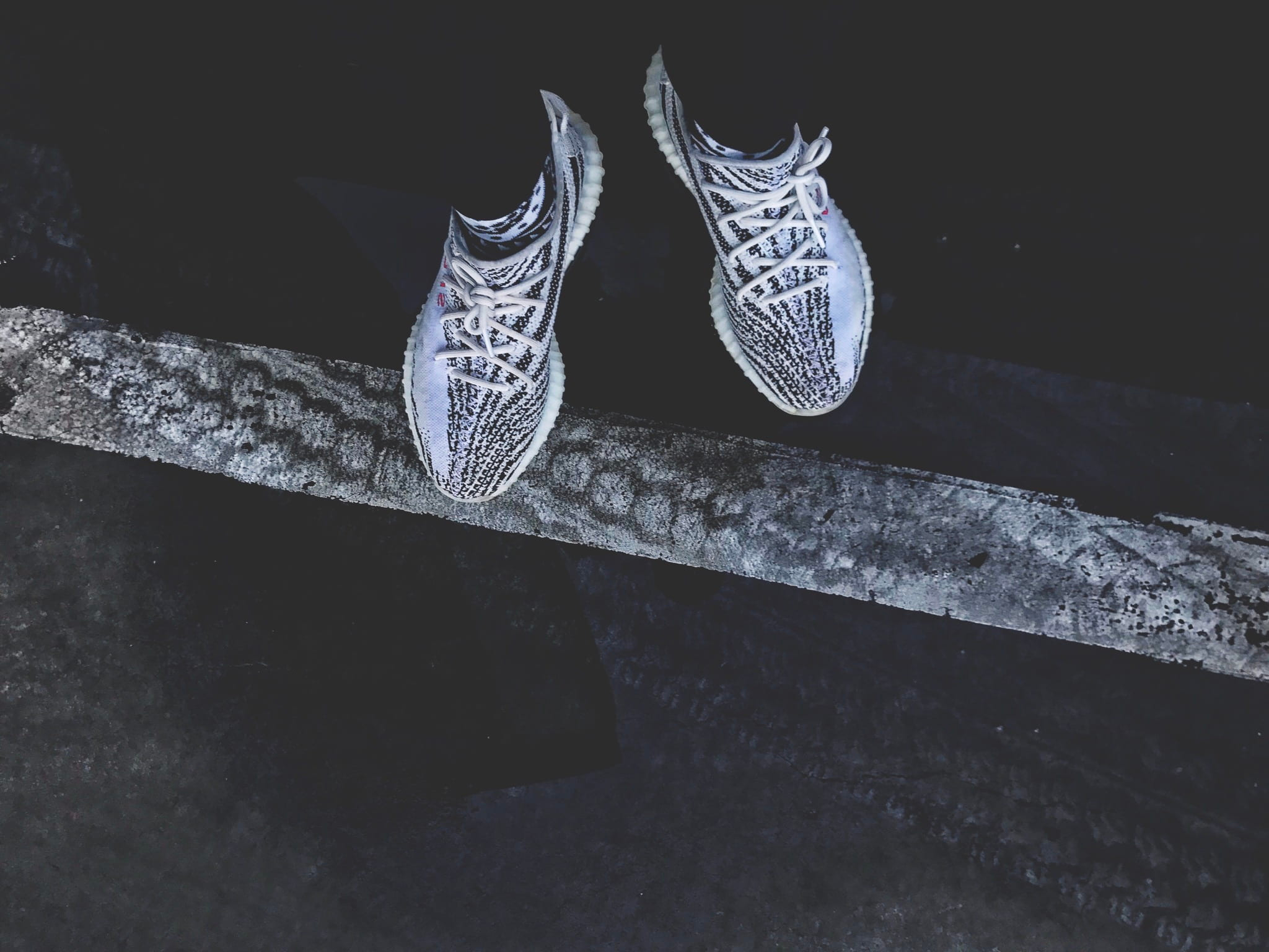 Pair of gray-and-black adidas Yeezy Boost 350’s wallpaper, person standing wearing pair of white-and-black Adidas mid-top sneakers