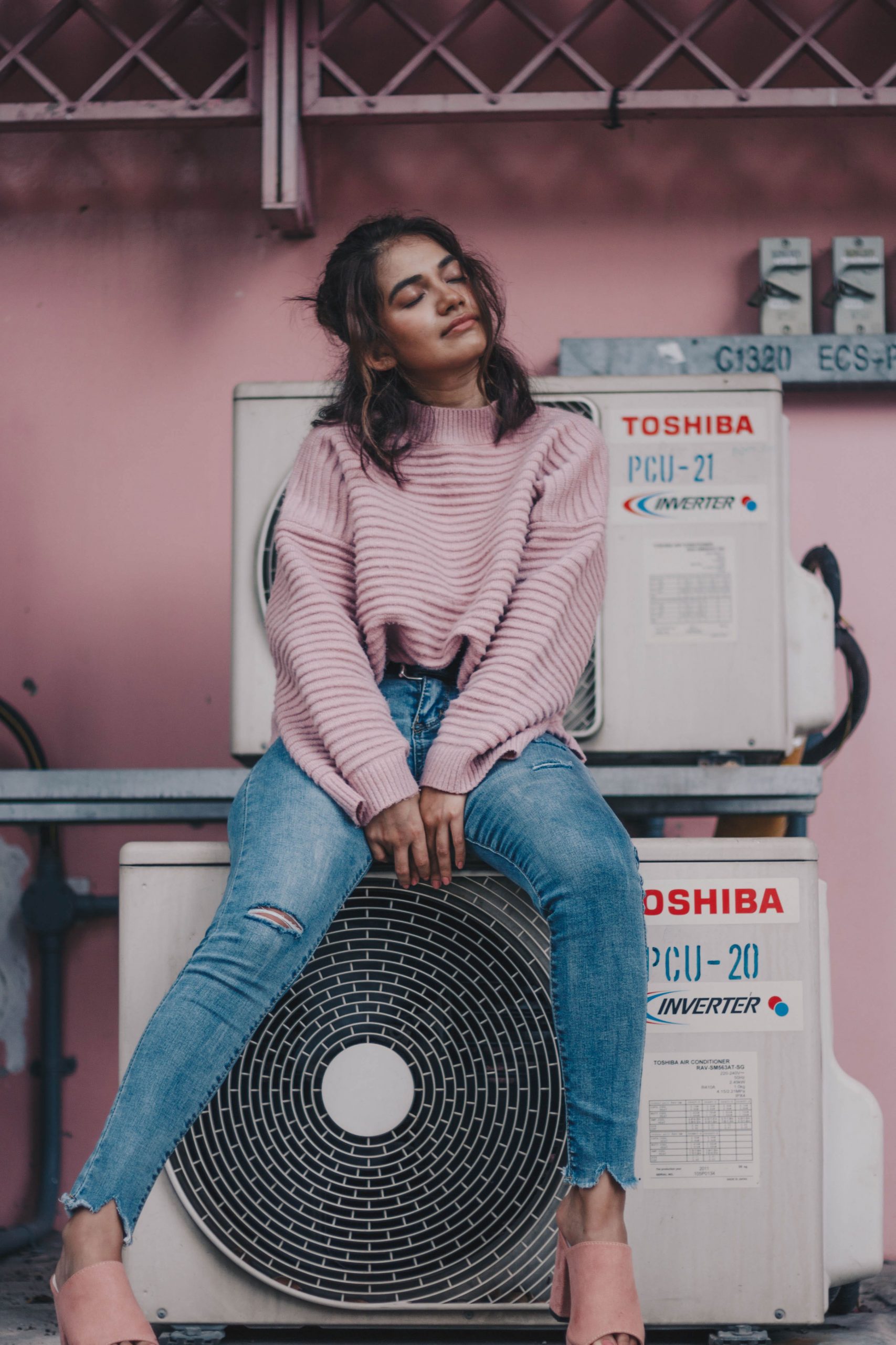 Woman sitting near Toshiba air condenser wallpaper