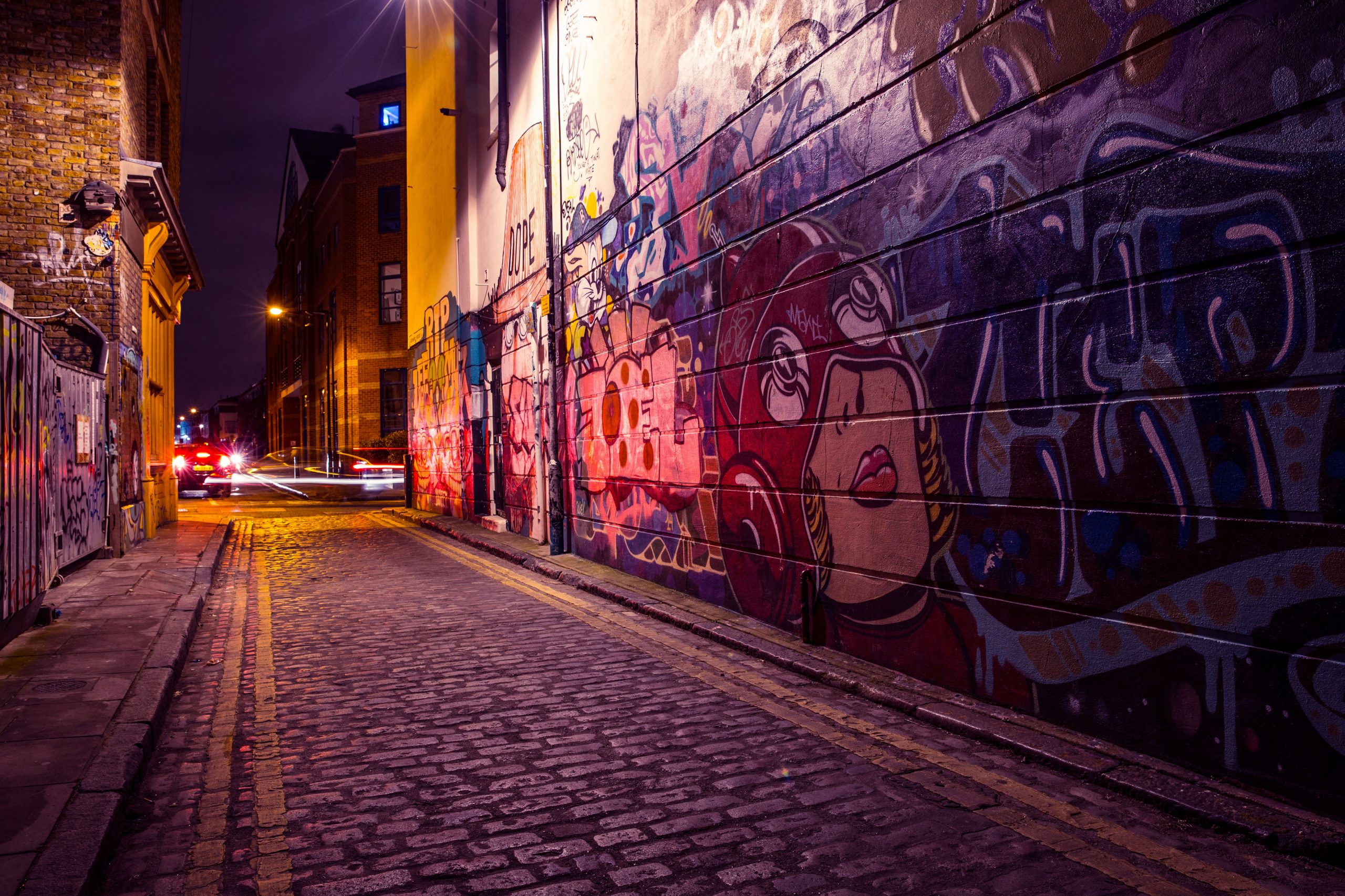 City side street with street art and graffiti captured by night wallpaper